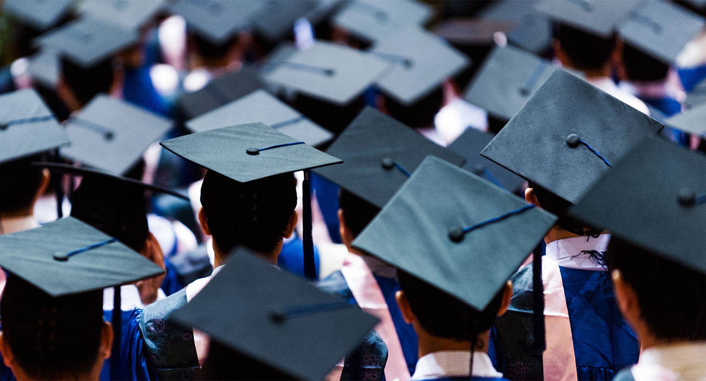 A crowd of graduation caps, viewed from the back